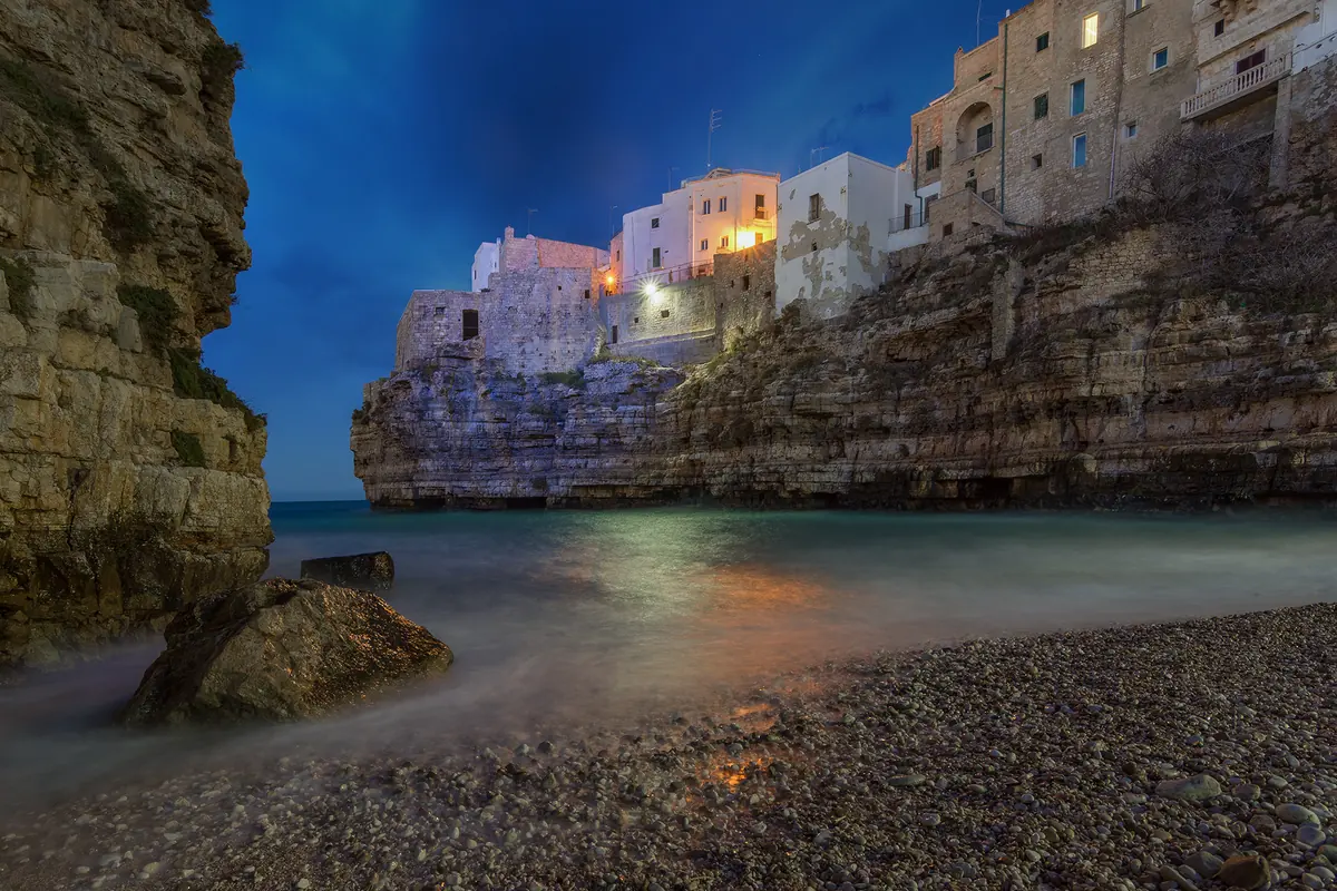 Lama Monachile cove beneath Polignano a Mare's illuminated old town
